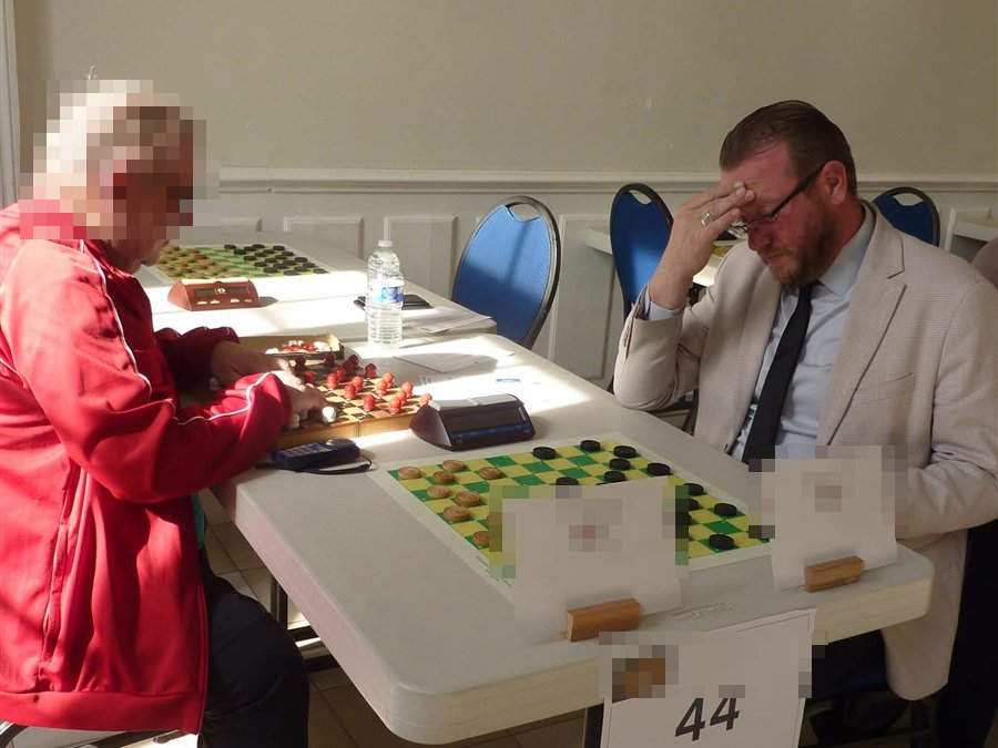 Arnaud Dufour à la table, main au front, pendant le championnat du monde amateur de jeu de dames