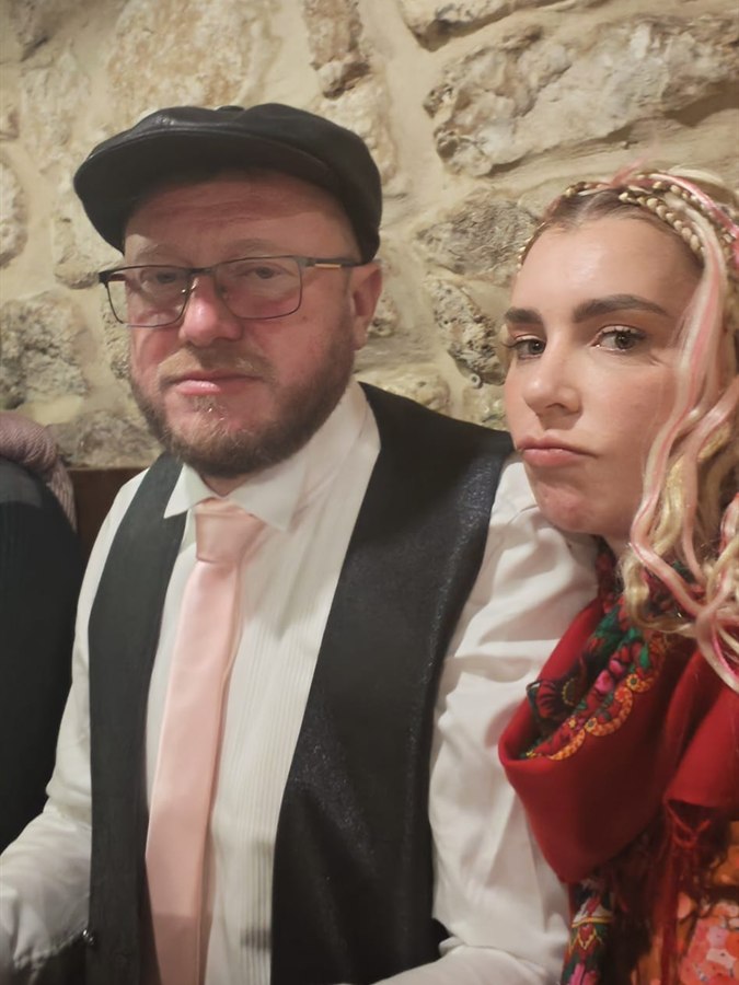 Eugénie et Arnaud Dufour en tenue de fête, devant un mur de pierre