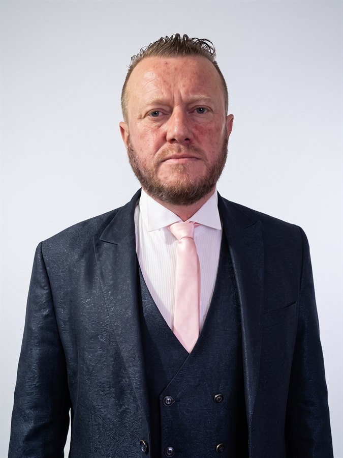 Arnaud Dufour en costume sombre et cravate rose